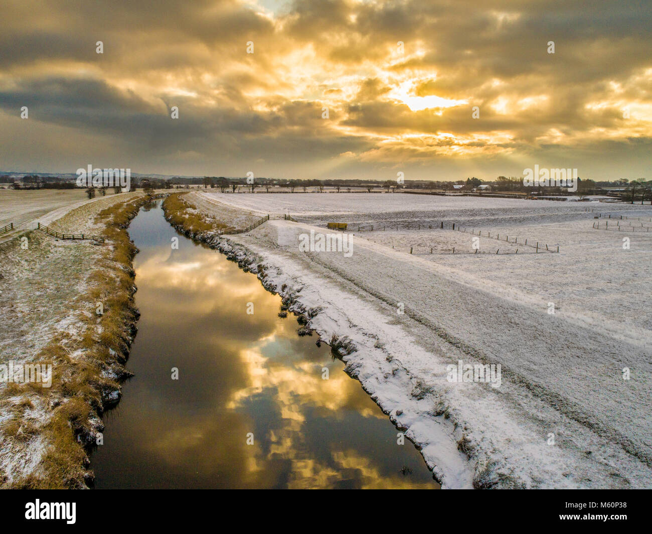 Great Eccleston, UK.  27th February 2018.  Drone captures sunrise over the snow covered fields around the River Wyre.  The clouds are reflected in the river and the frosty river bank can be seen on each side., with the Pennines in the background. Russell Millner / Alamy Live News. Stock Photo