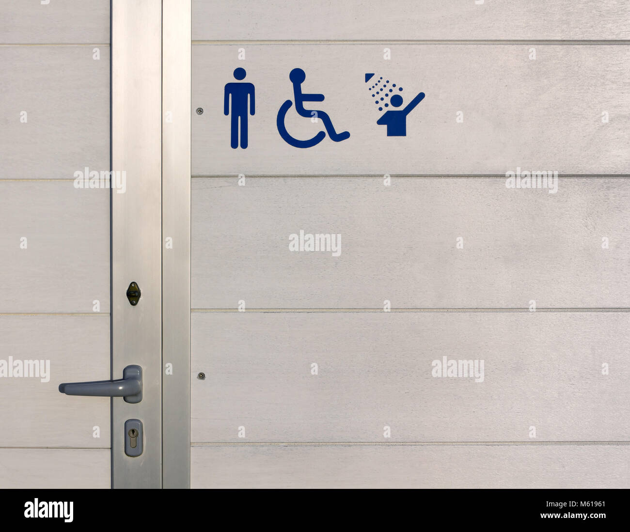 Blue signs over the exterior wall of a beach gents public bathroom ...