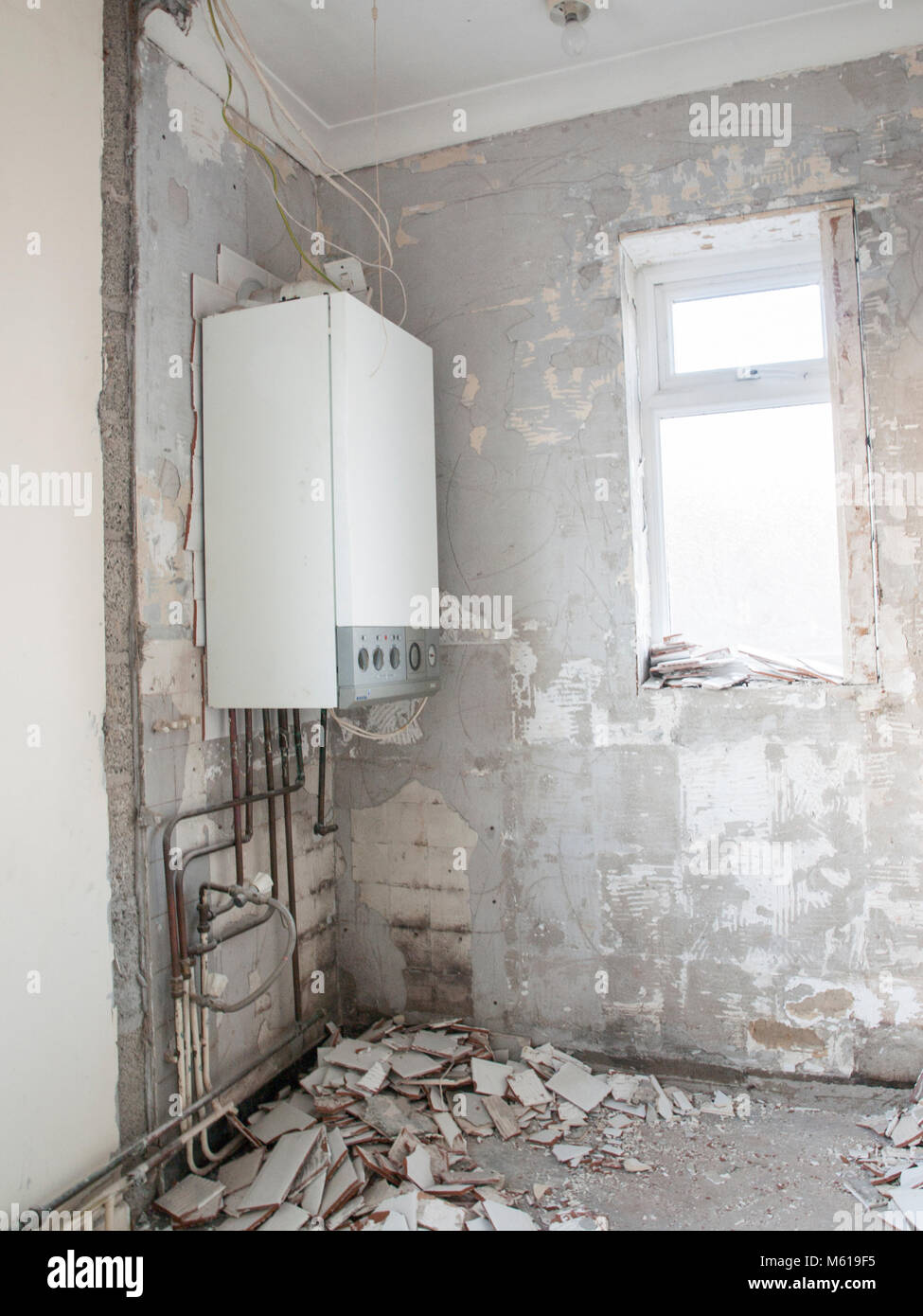 Flat during renovation process. Ripped out tiles and broken boiler Stock Photo Alamy
