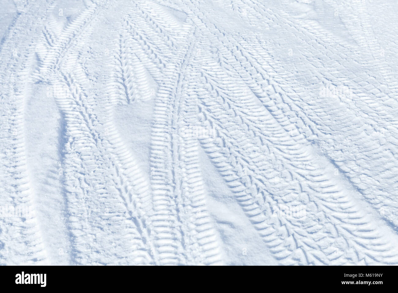 Tire tracks pattern on winter road covered with snow. Background texture Stock Photo