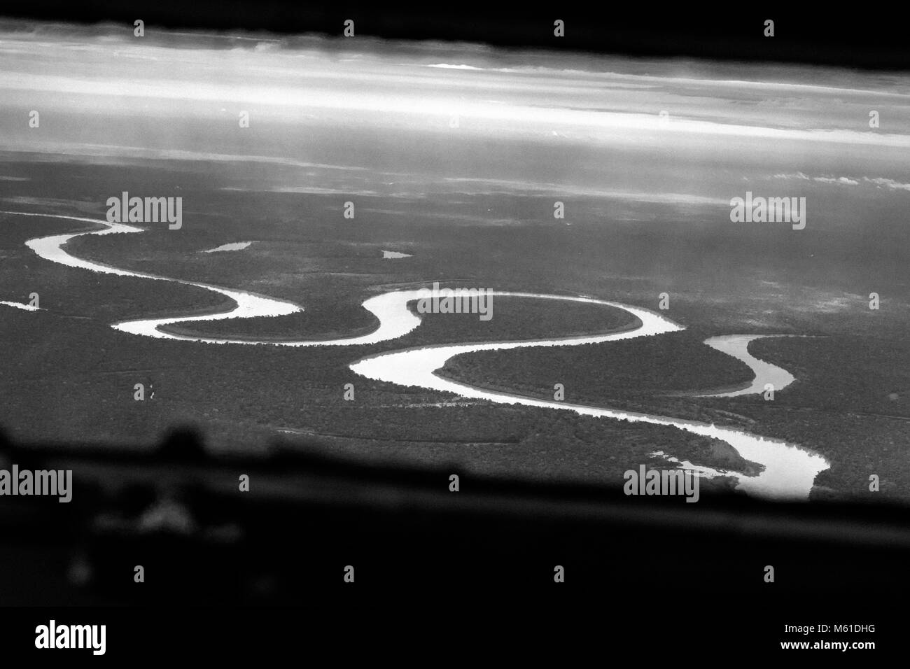 Vast expanses of Amazonian tropical rainforest, traversed by rivers and canals, are seen from the cockpit of a Douglas DC-3 aircraft, landing in the remote department of GuainÃa, Colombia, 9 December 2016. Although most of the airplanes of the DC-3 series were built in 1940s, today, almost 80 years after, some of them still continue to fly in a daily service, traversing the endless savannas and jungles in the in southeastern Colombia. Transporting people, groceries, livestock, or even small vehicles, a legendary American airplane is sometimes the only connection between remote jungle villages Stock Photo