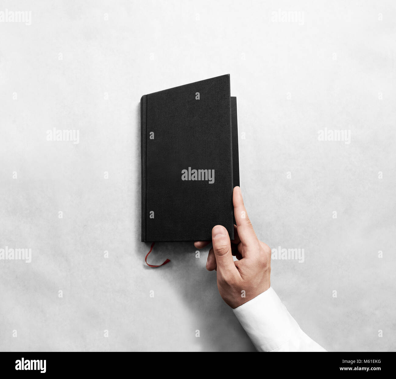 Hand open blank black book cover mock up template. Clear booklet surface design mockup. Arm holding opened textbook diary. Reading grey notebook copy. Stock Photo