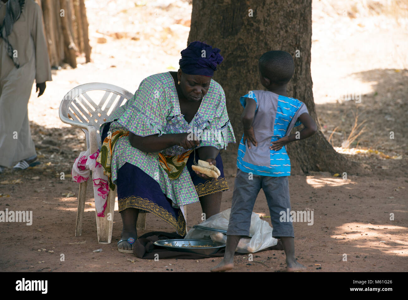 an-ethnic-mandinka-mandingo-woman-making-a-sandwich-for-sale-to-a