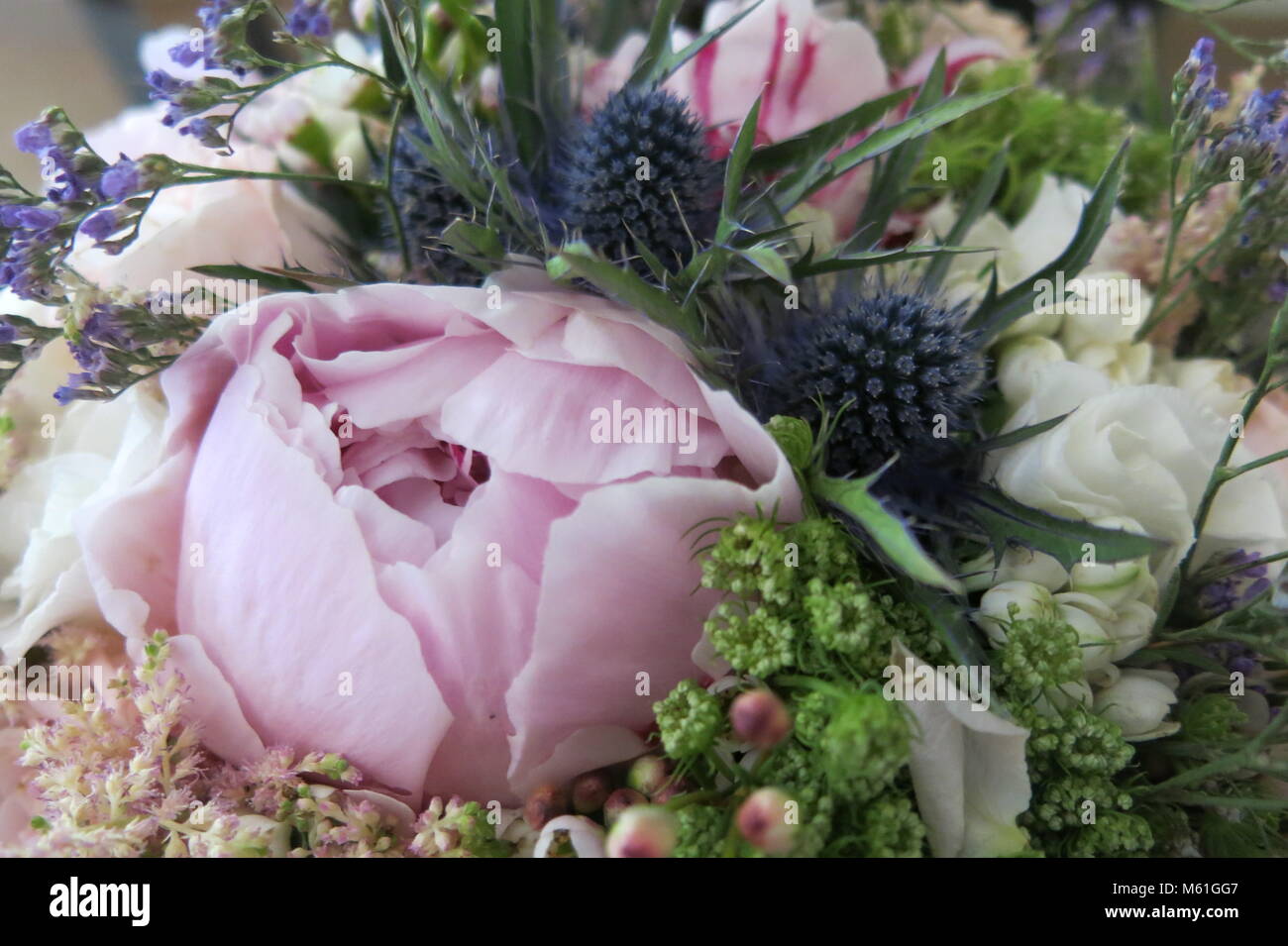 A blowsy, romantic bridal bouquet in pink, white and blue Stock Photo