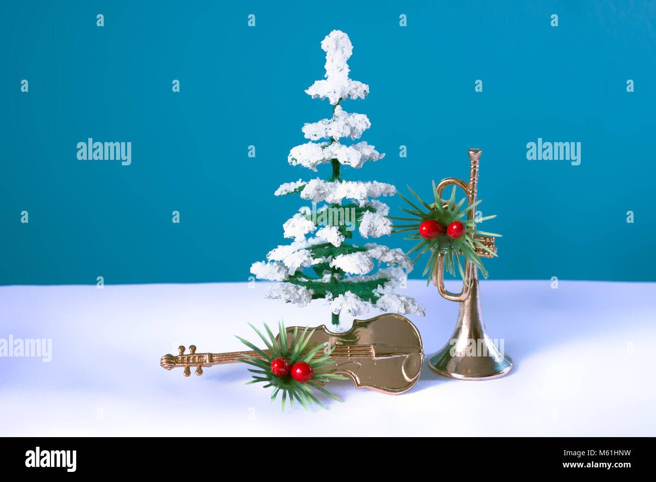 Snowy tree with violin and trumpet festively decorated with a blue background. Christmas still life for musicians. Stock Photo