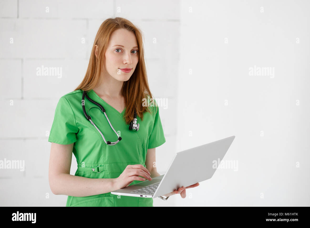 Portrait of beautiful friendly doctor using laptop computer Stock Photo
