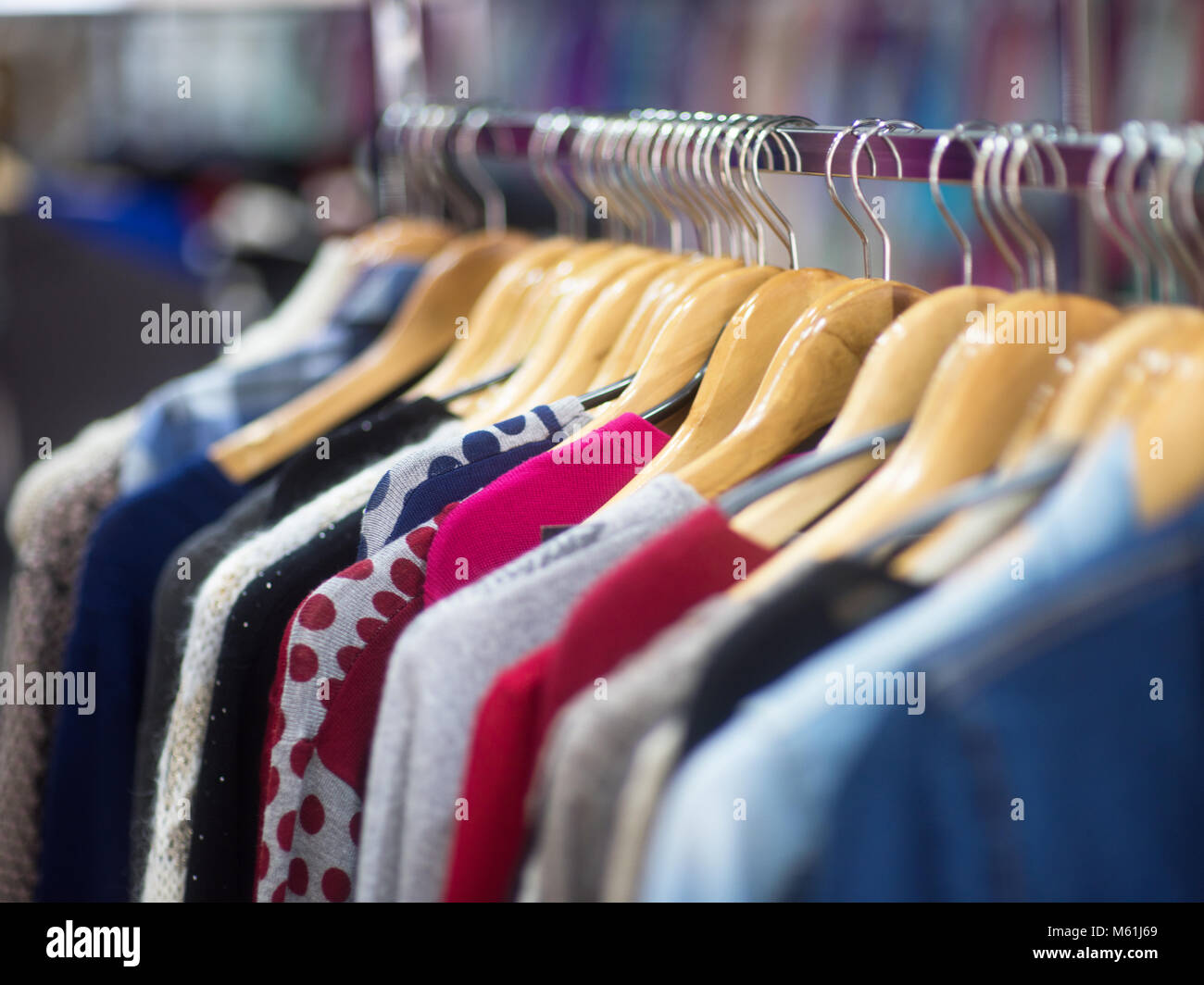 Fashionable clothes on hangers in a store Stock Photo