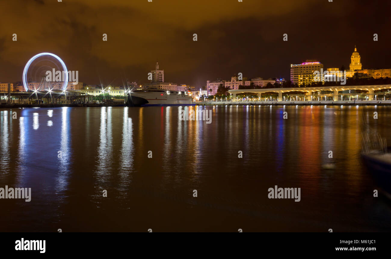 Night view of the waterfront of Malaga city, Spain, with the Cahedral's steeple in the background Stock Photo