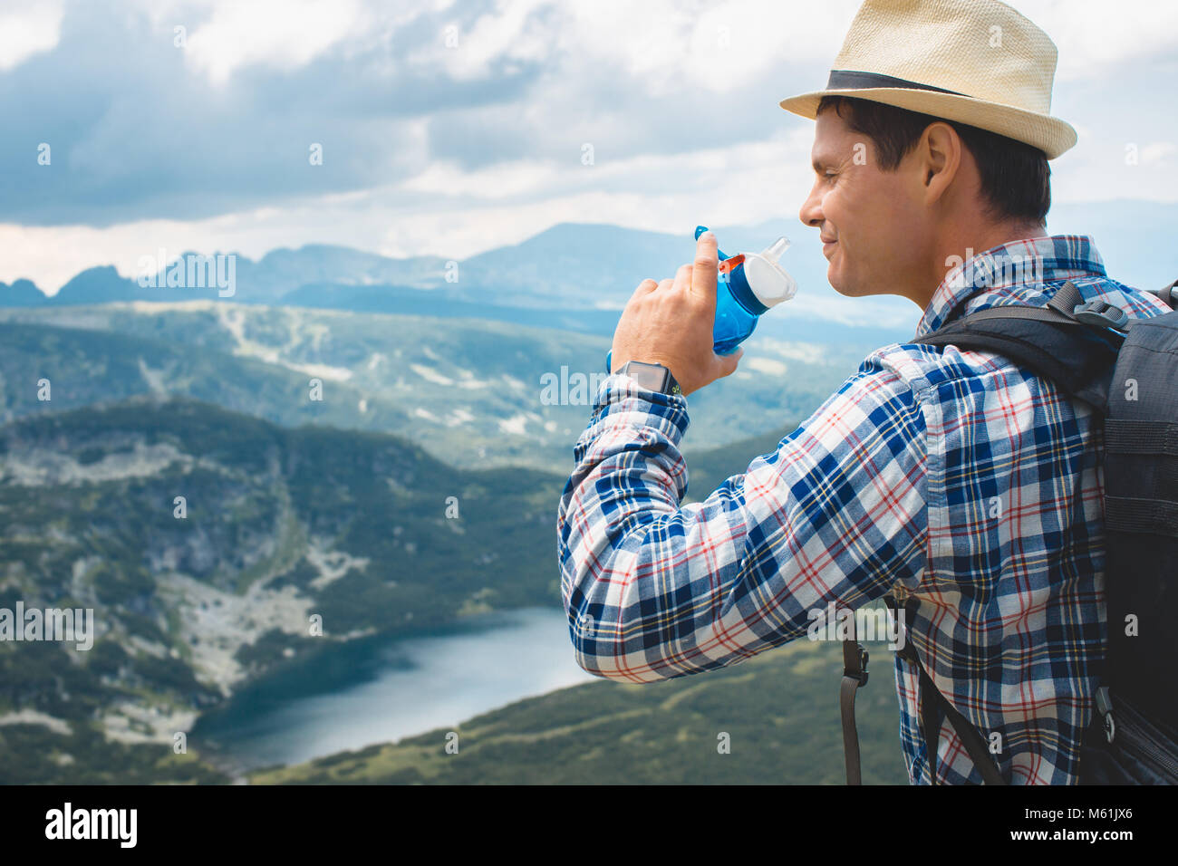 Traveler drinks water in the mountains Stock Photo