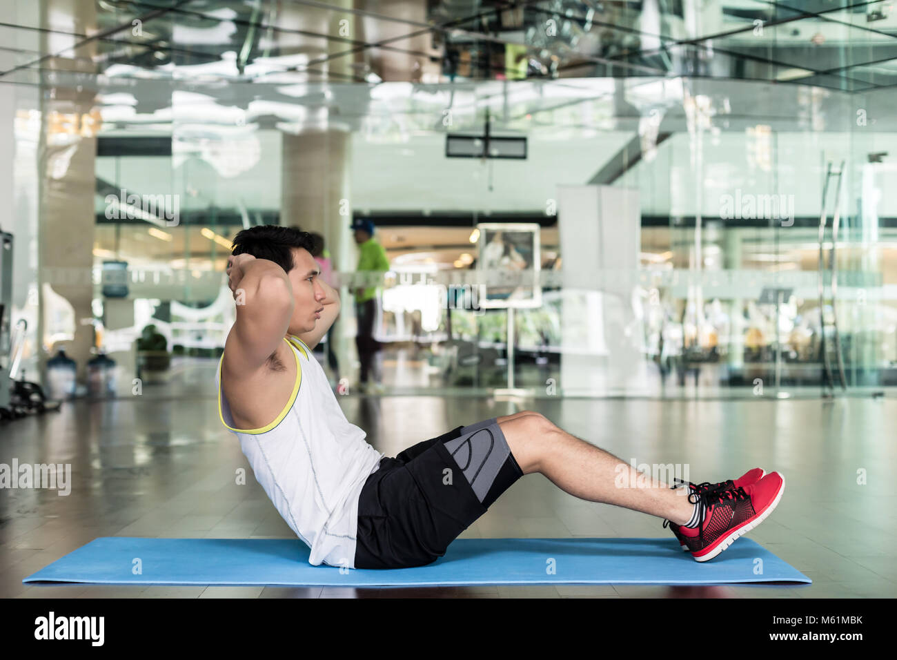 Young man sitting down while doing crunches for the abdominal muscles Stock Photo Alamy