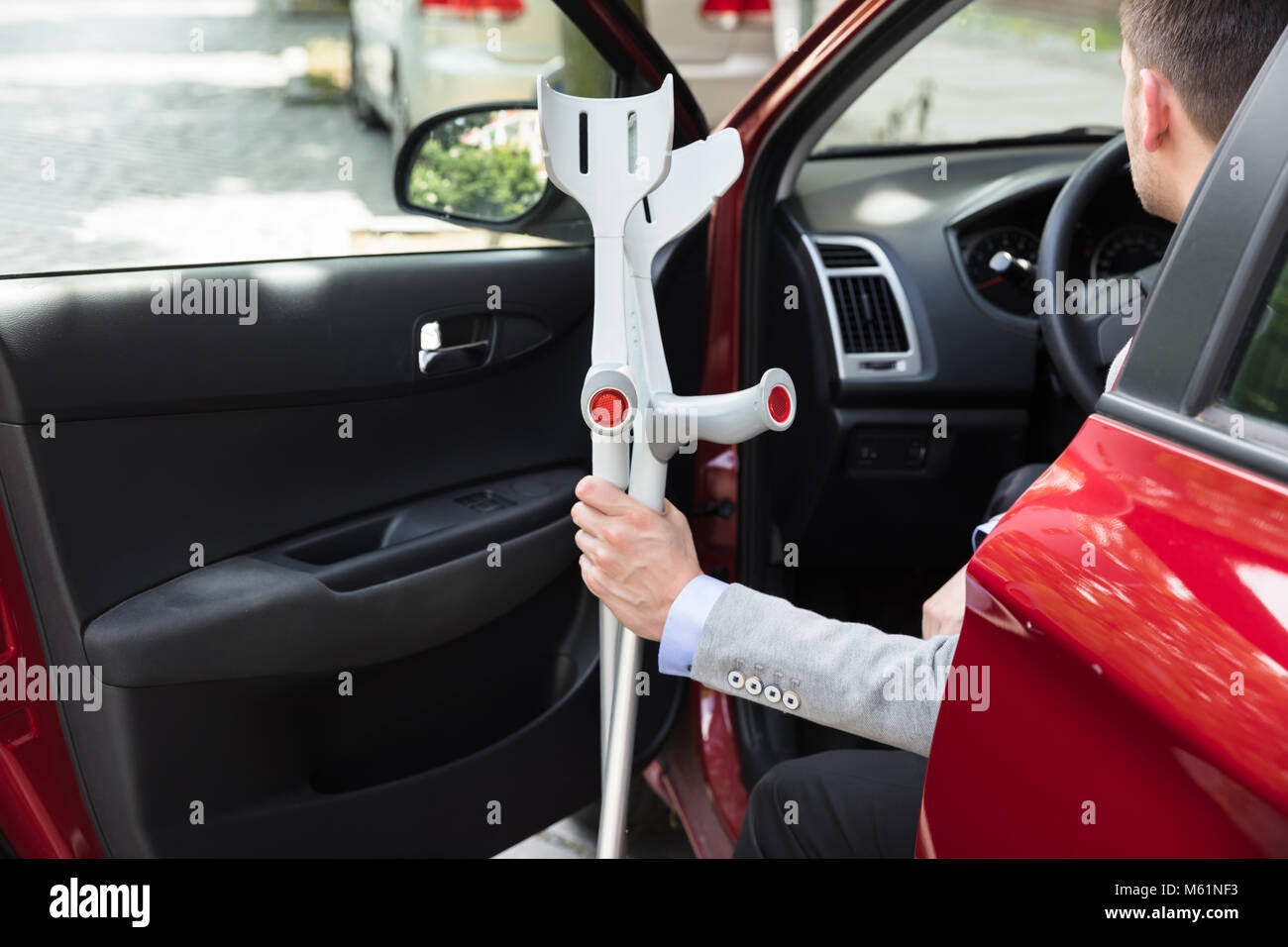 Disabled Person With Crutches Standing Near Open Door Of A Car Stock Photo