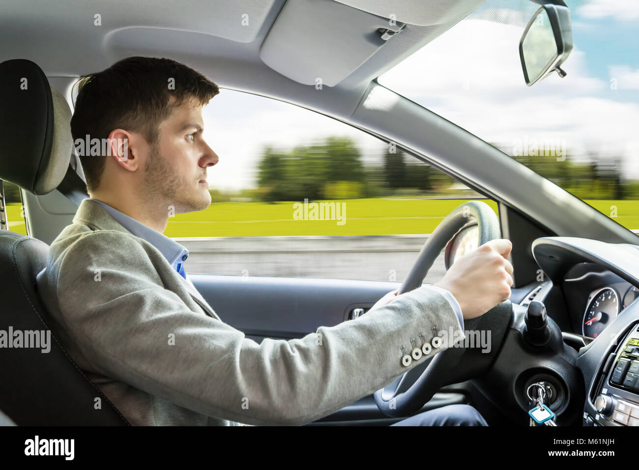 Close-up Of A Young Man Driving Red Car Stock Photo