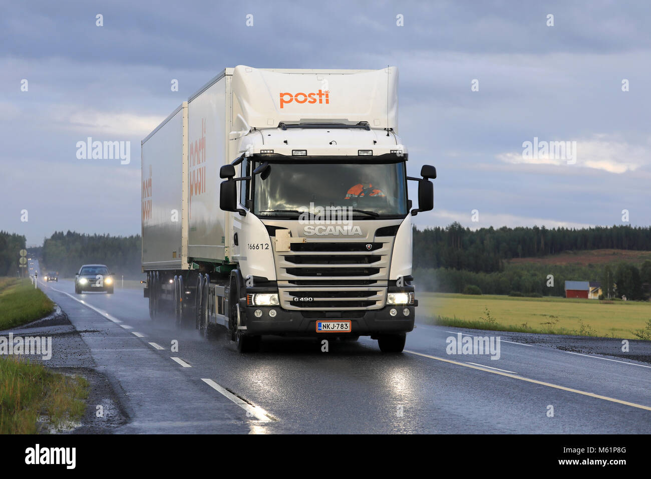 KOSKI TL, FINLAND - AUGUST 13, 2018: White Scania G490 cargo truck for Finnish Posti deliveries moves along highway on a rainy evening in South of Fin Stock Photo