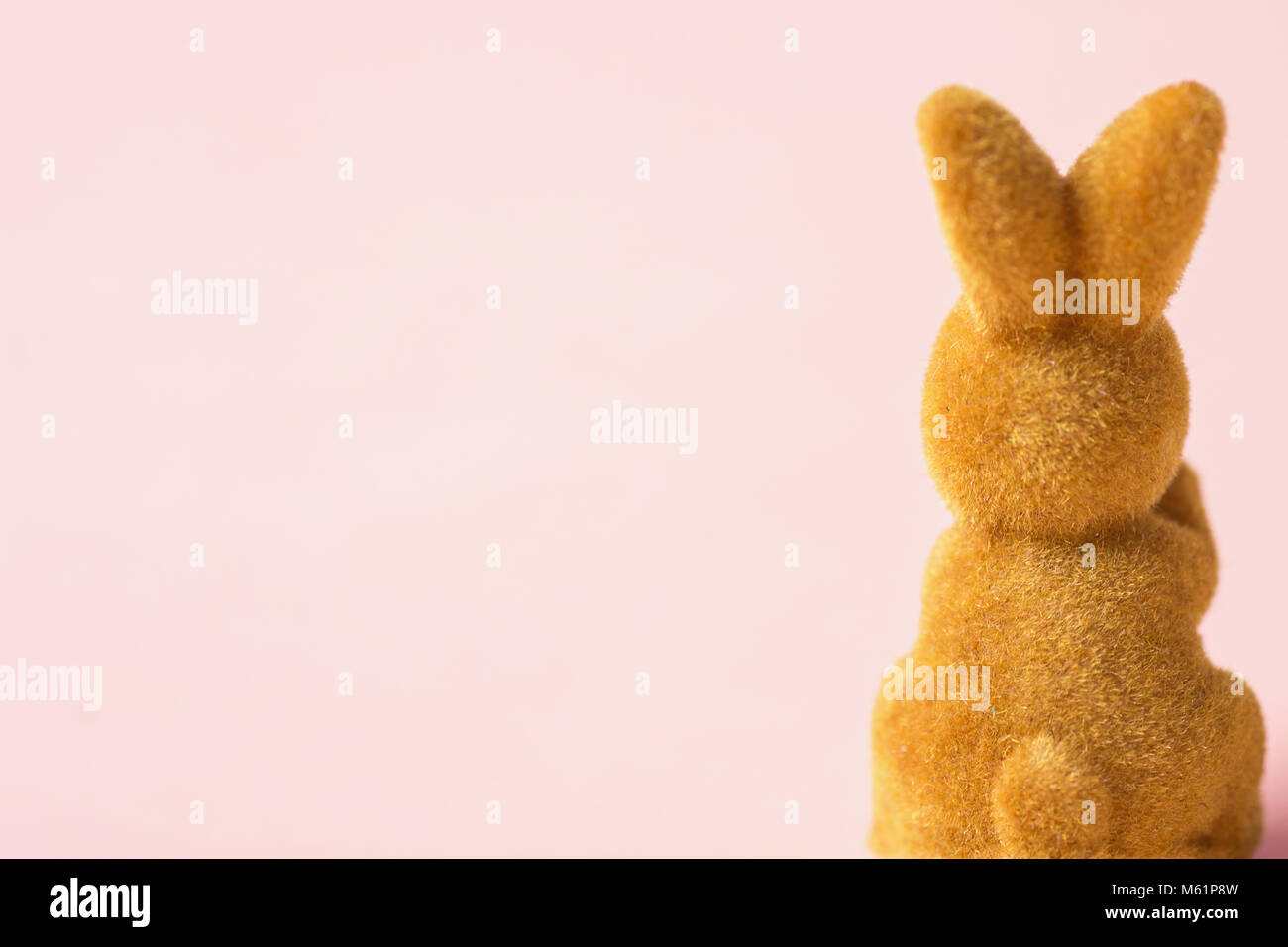 Fluffy Brown Toy Easter Bunny Sitting with his Back to the Viewer on Pink Fuchsia Background. Holiday Banner Poster Greeting Card Template. Creative M Stock Photo