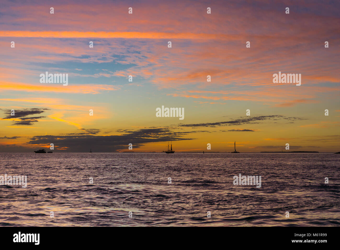 USA, Florida, Painted sky after sunset at beach with many boats on water Stock Photo