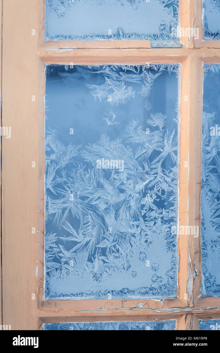beautiful-wooden-window-with-frozen-ice-flowers-in-norwegian-town-stock