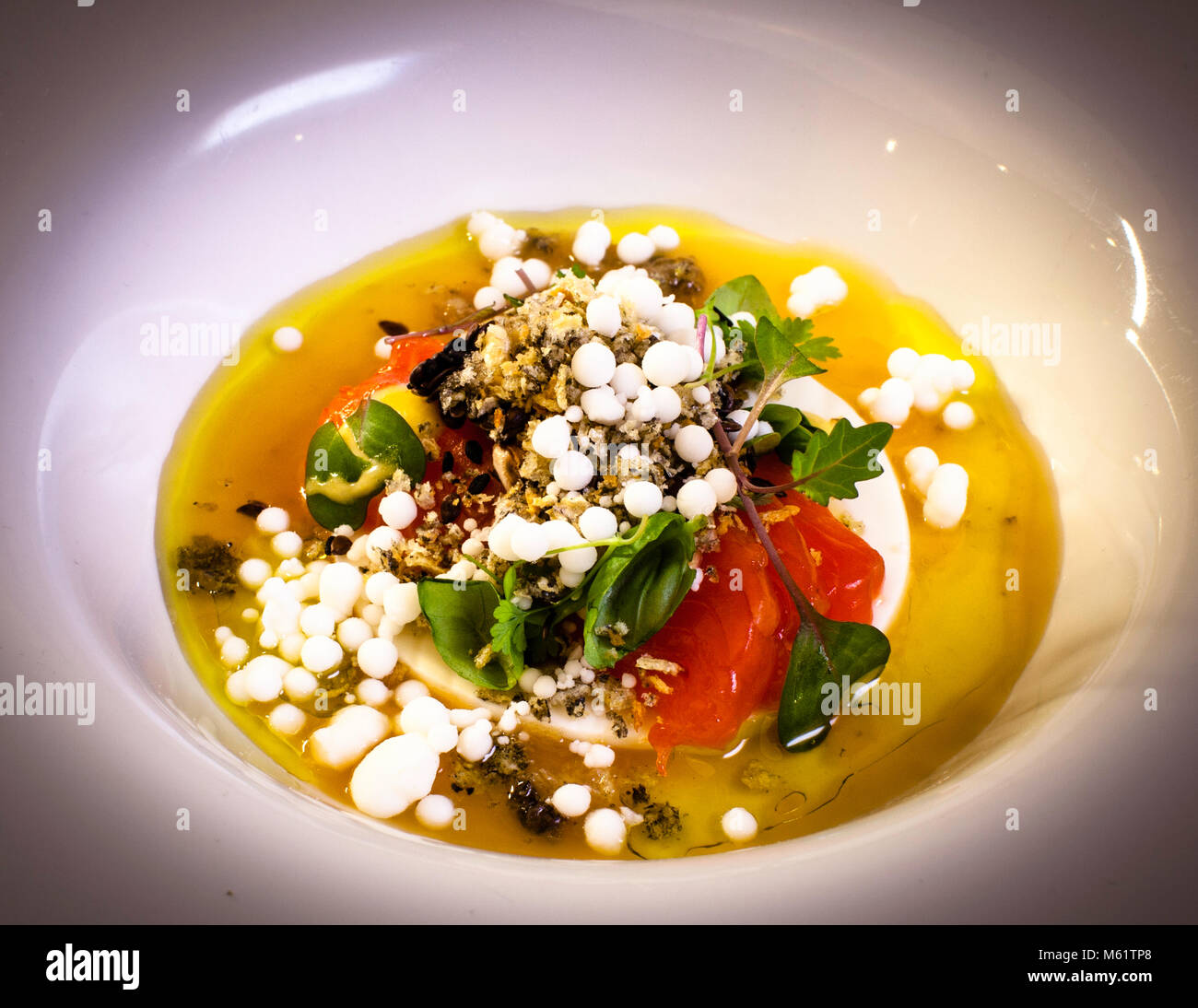 Cooked cow's milk with trout and tomato tea by Michelin Star Chef Marco Müller Stock Photo