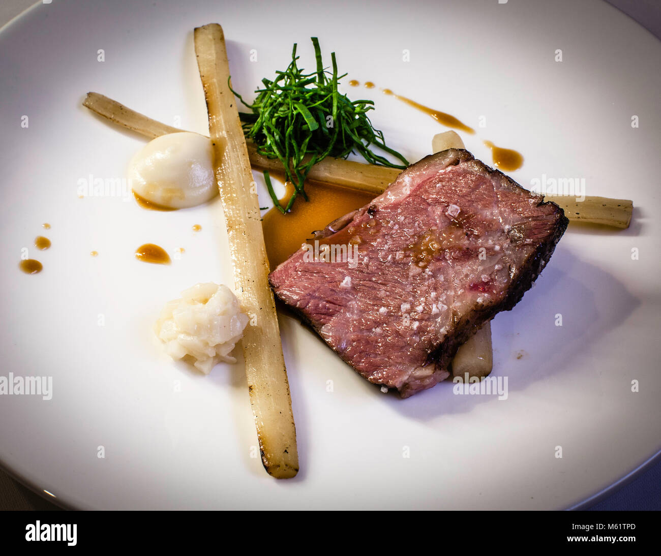 Grilled beef breast with salsify and sunflower root by Michelin Star Chef Marco Müller Stock Photo