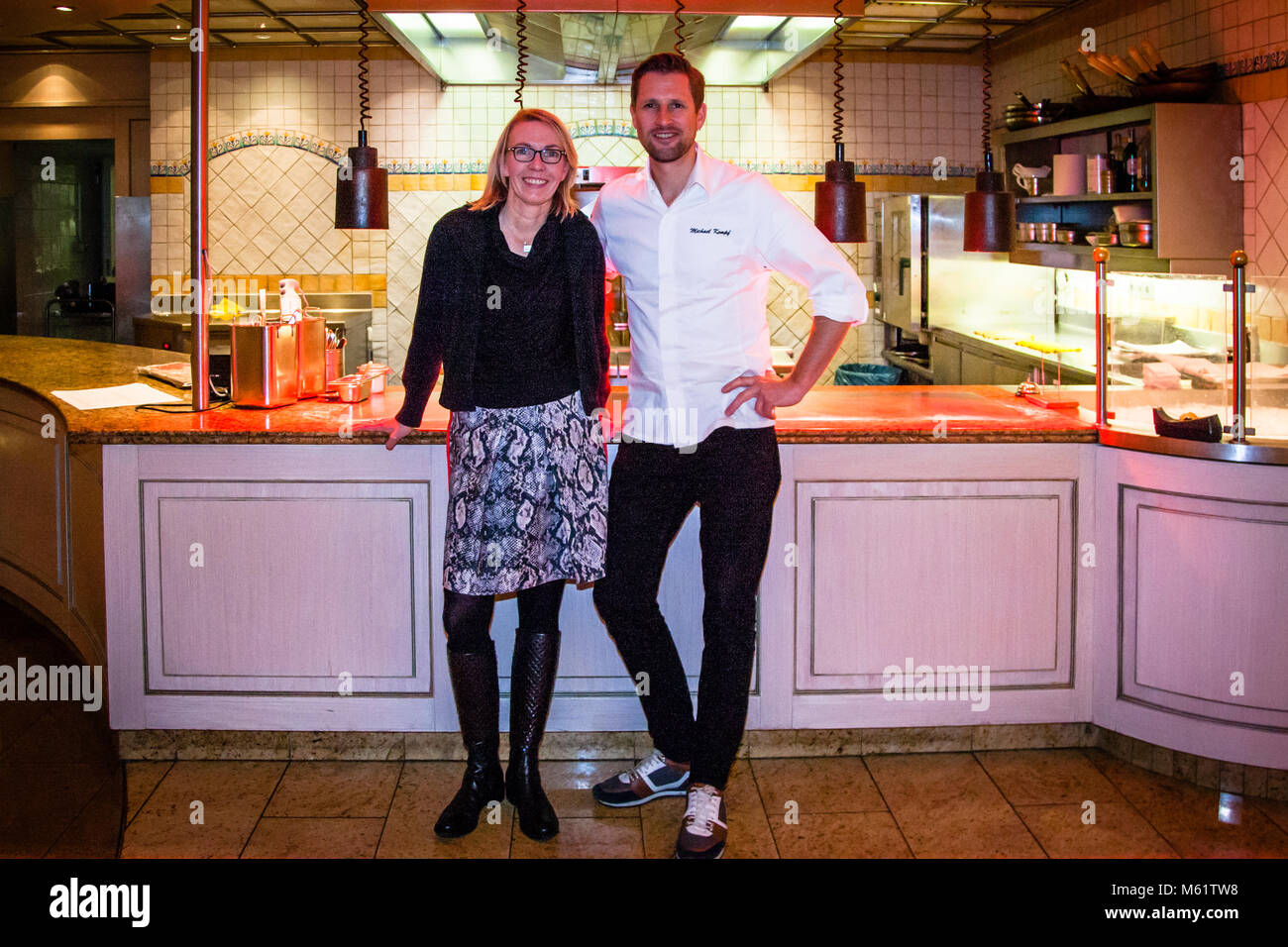 German Michelin star chef Michael Kempf together with reporter Angela Berg in front of the open kitchen at Parkhotel Ahrensburg, Germany Stock Photo
