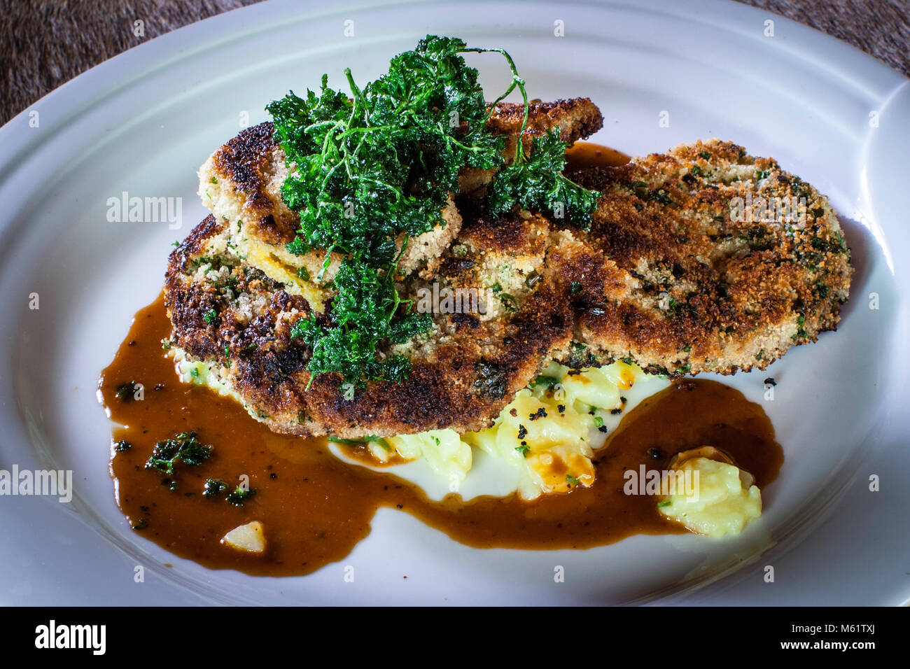 This is how the venison schnitzel then lies fragrant on the plate in bavarian beer garden Prinzregent Luitpold in Oberstdorf typical bavarian dishes like veal sausage or Schnitzel, regional cooking with hay Stock Photo
