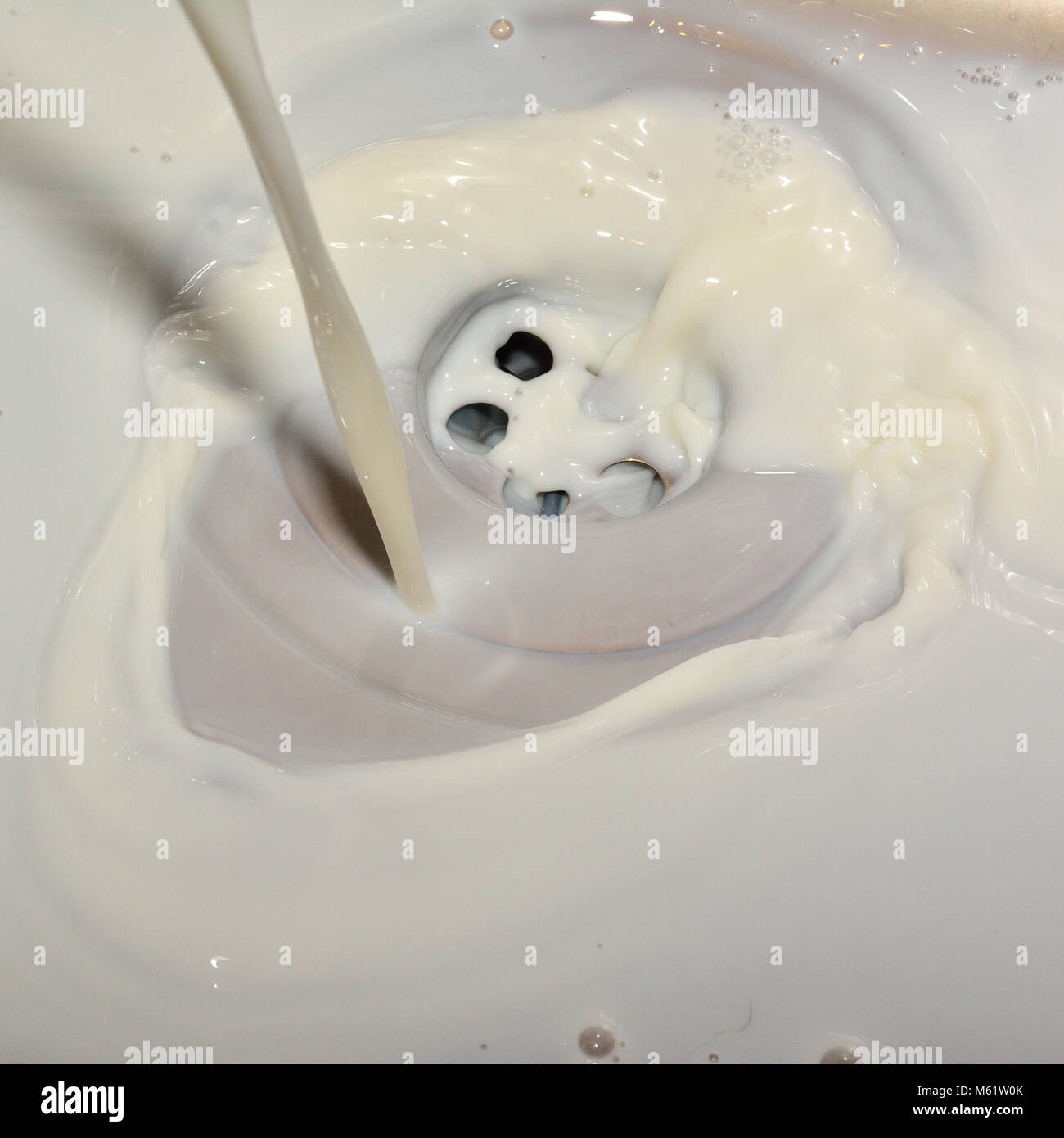 milk poured down sink hole Stock Photo Alamy