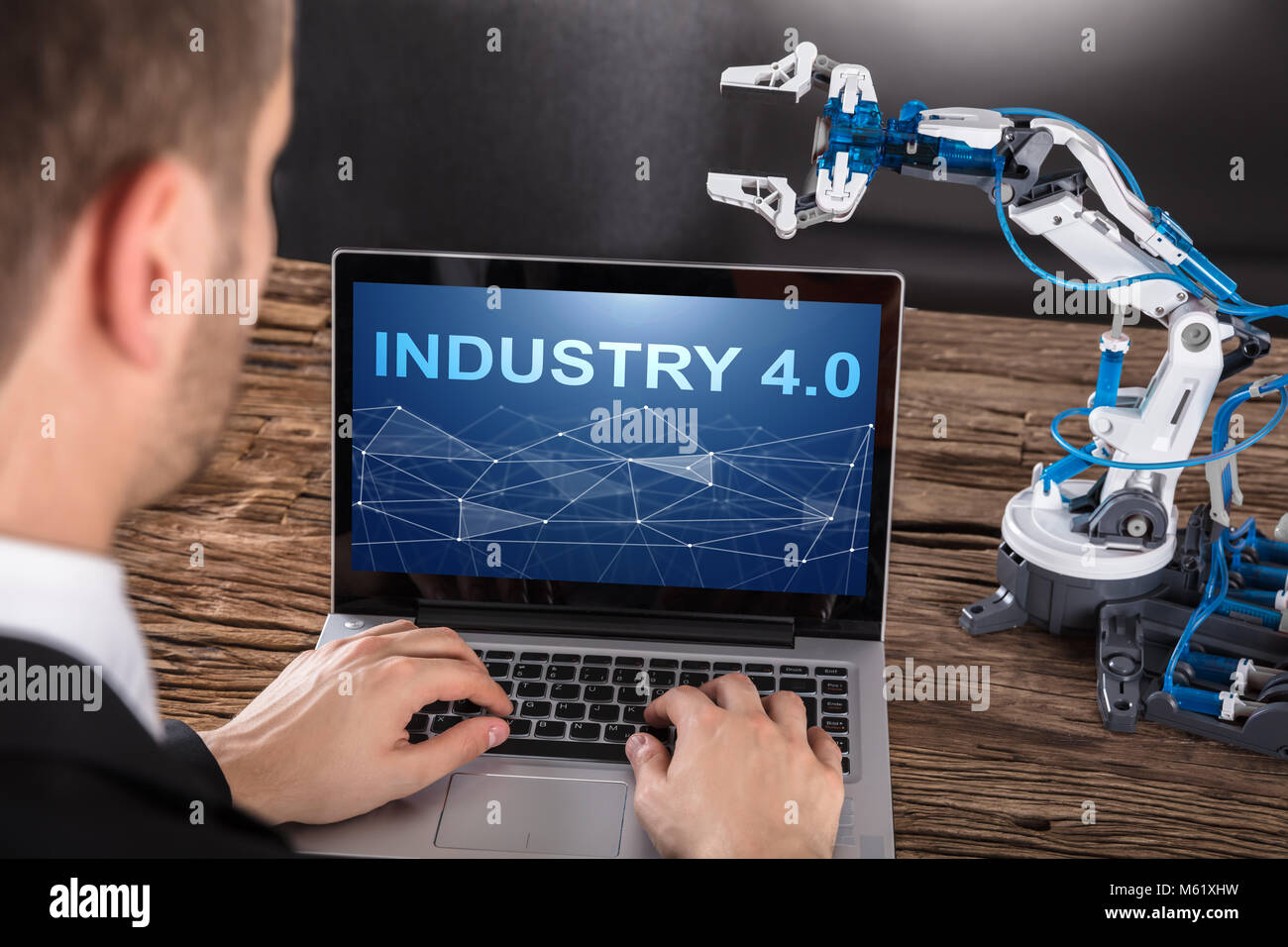 Close-up Of Businessperson Working On Design Of Industrial Robot Arm On Laptop Stock Photo
