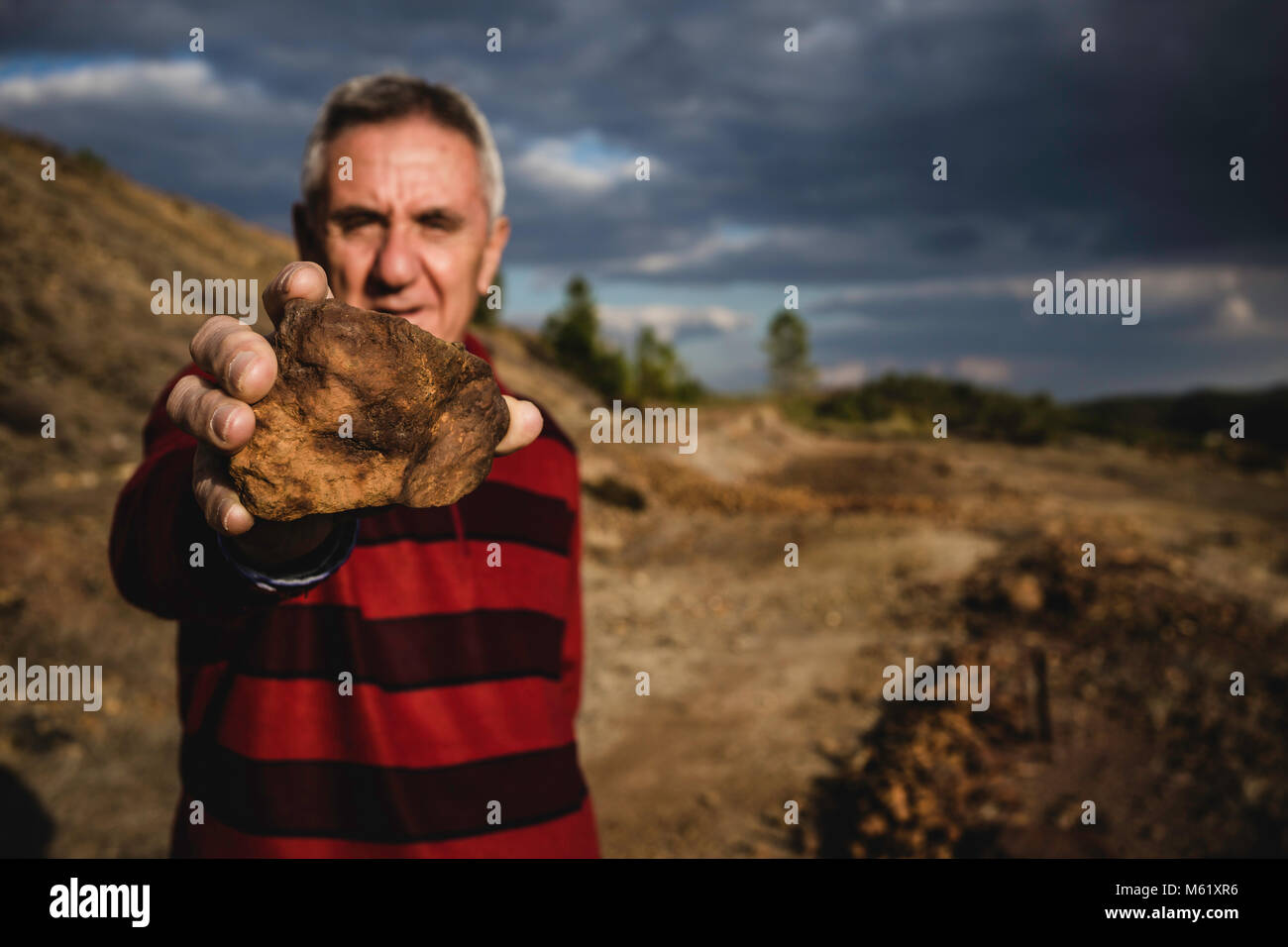 Elderly man showing mineral stone Stock Photo