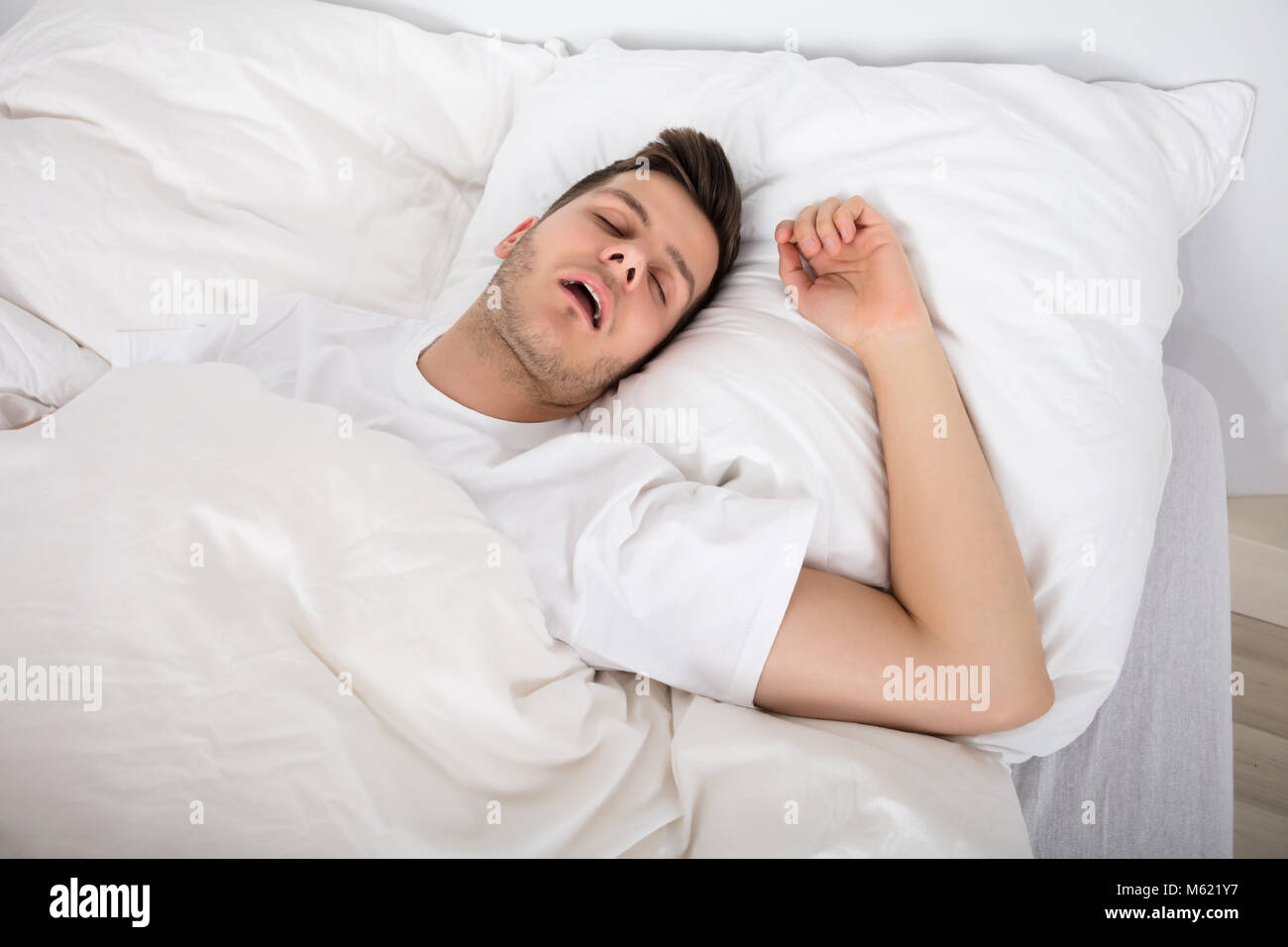 View Of Tired Young Man Snoring While Deep Sleeping In Bed Stock Photo Alamy