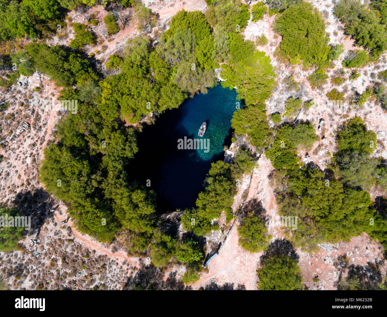 Melissani Cave Cephalonia (Kefalonia) viewed from above with tourists entering the cave by boat Stock Photo
