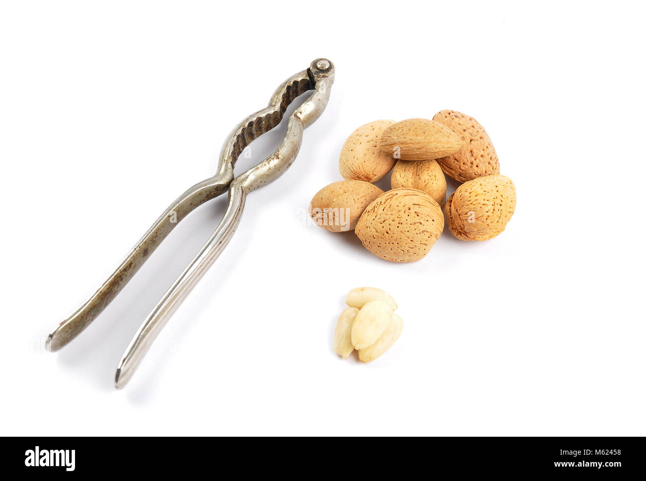 Almonds with and without shell and nutcracker on white Stock Photo Alamy