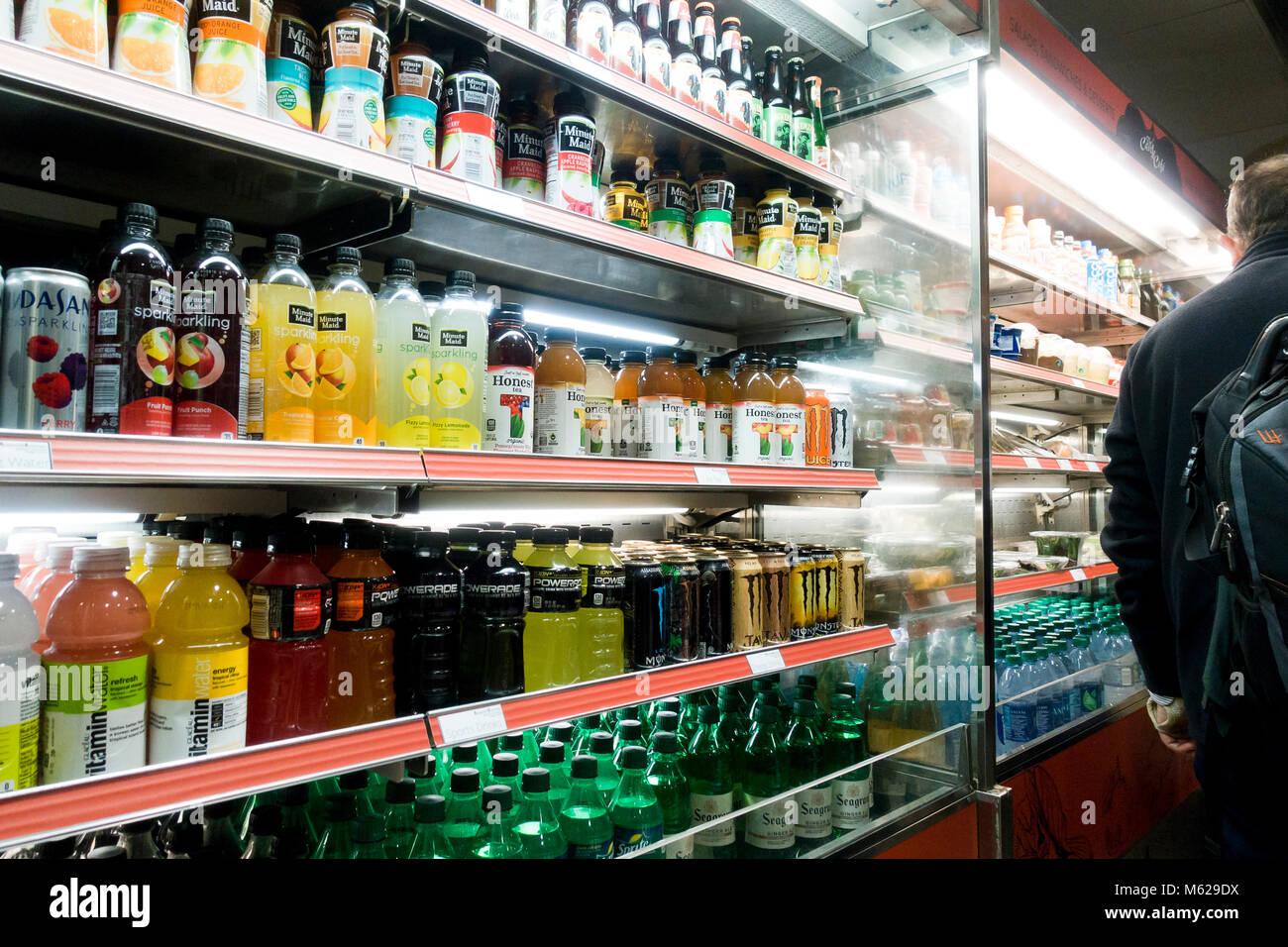 Cold carbonated drinks and bottled vitamin water in open display refrigerator at a convenience store - USA Stock Photo