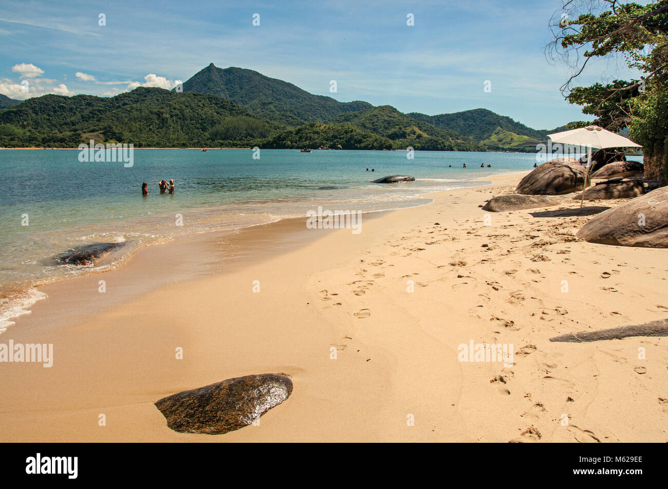 View of beach, sea and forest on sunny day in Ilha do Pelado, a tropical beach near Paraty, an historic town totally preserved in the Brazilian coast. Stock Photo