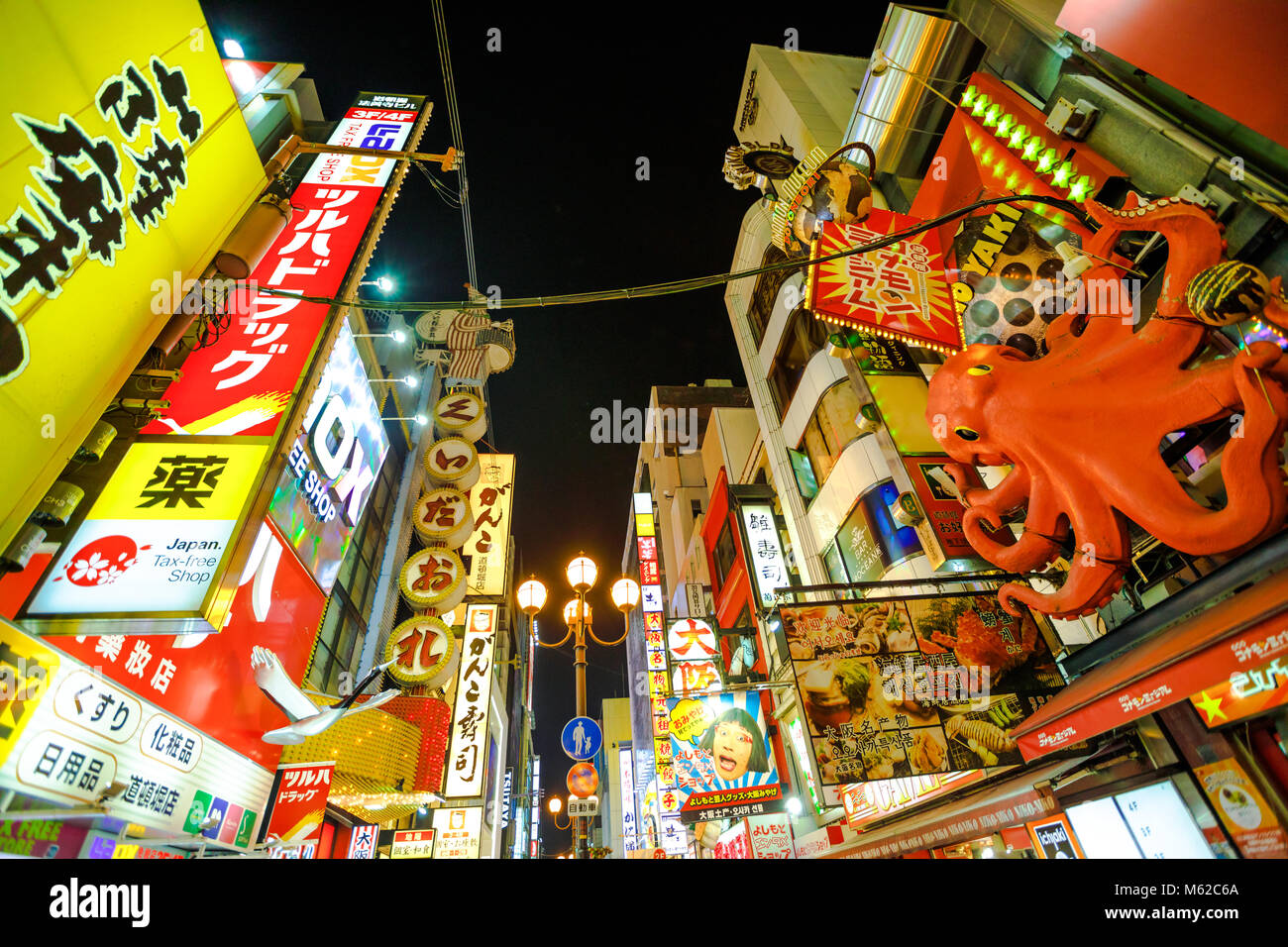 Osaka, Japan - April 29, 2017: bottom view of bright neon signboard at night and mechanic Kani Doraku crab sign of popular Japanese restaurant in Dotonbori area of Osaka, Namba District. Night scene. Stock Photo