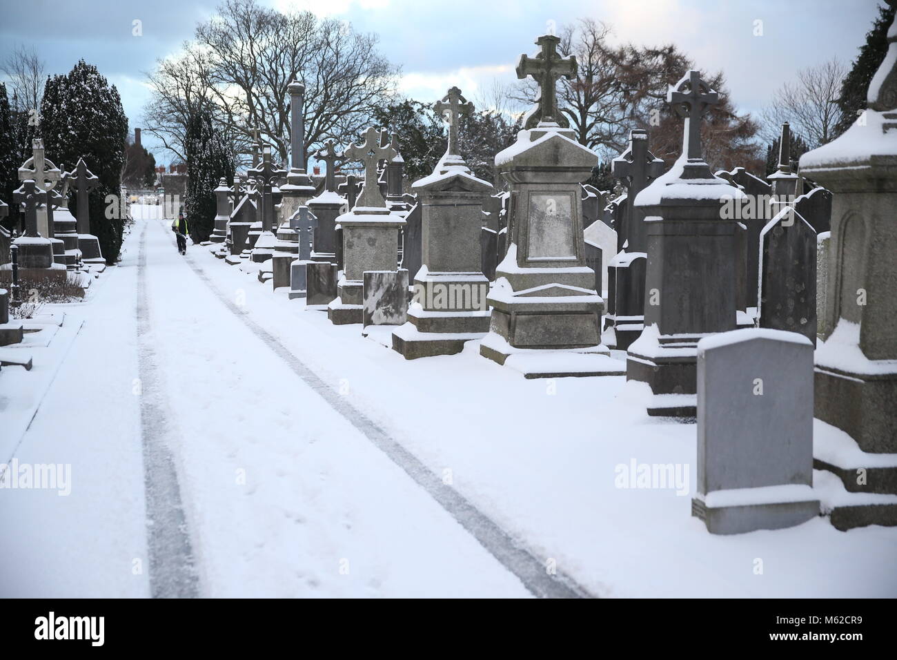 A snow-covered path through Glasnevin cemetery in Dublin as heavy snow has caused more misery for travellers overnight. Stock Photo