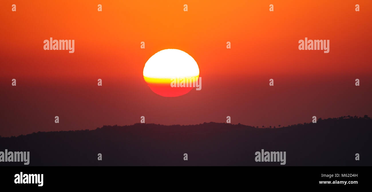 Beautiful sunset with orange sky and sun over mountain range Stock ...