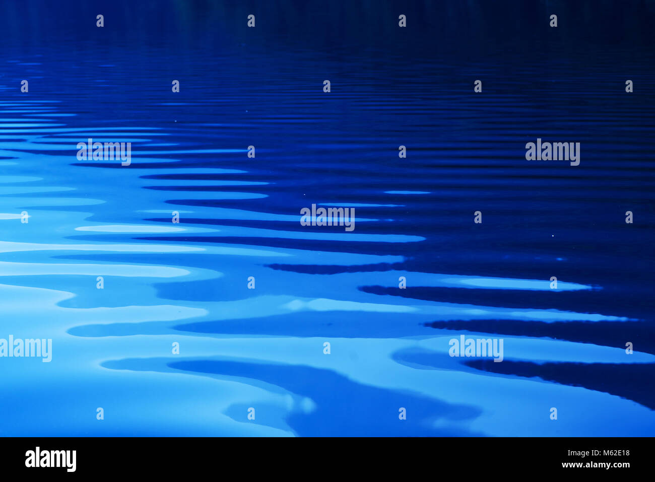 Blue rippled water as abstract background. Tranquil surface texture of the lake. Stock Photo