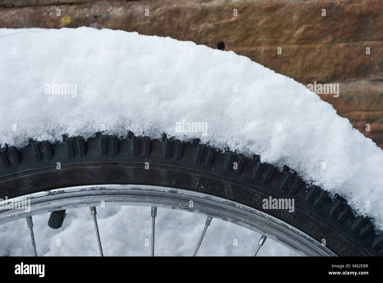 Thick snow on a bicycle wheel Stock Photo