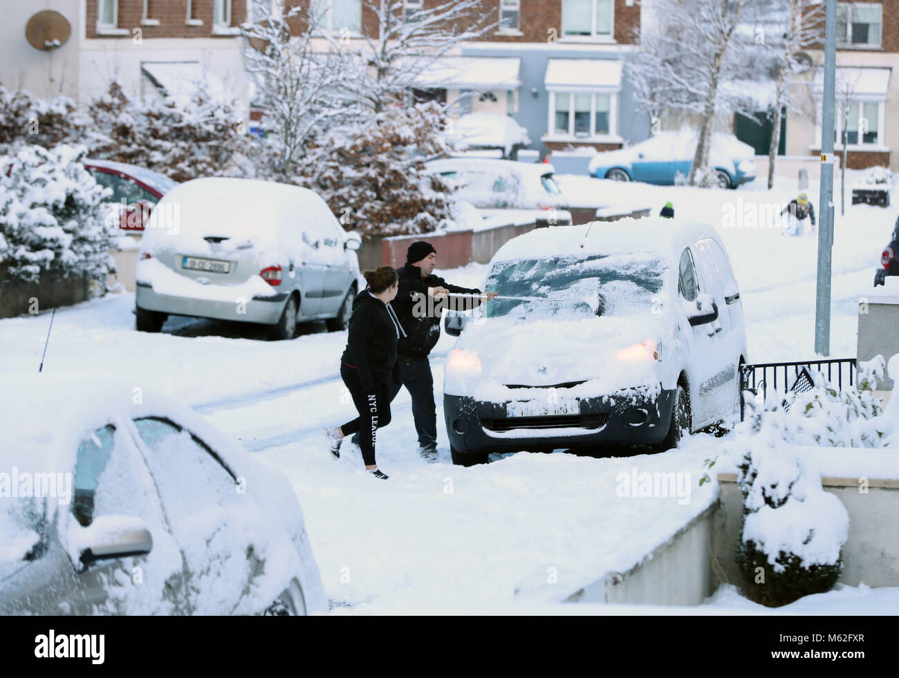 People clear snow from their cars in Athy, Co Kildare, as wintry conditions have caused more misery for travellers overnight. Stock Photo