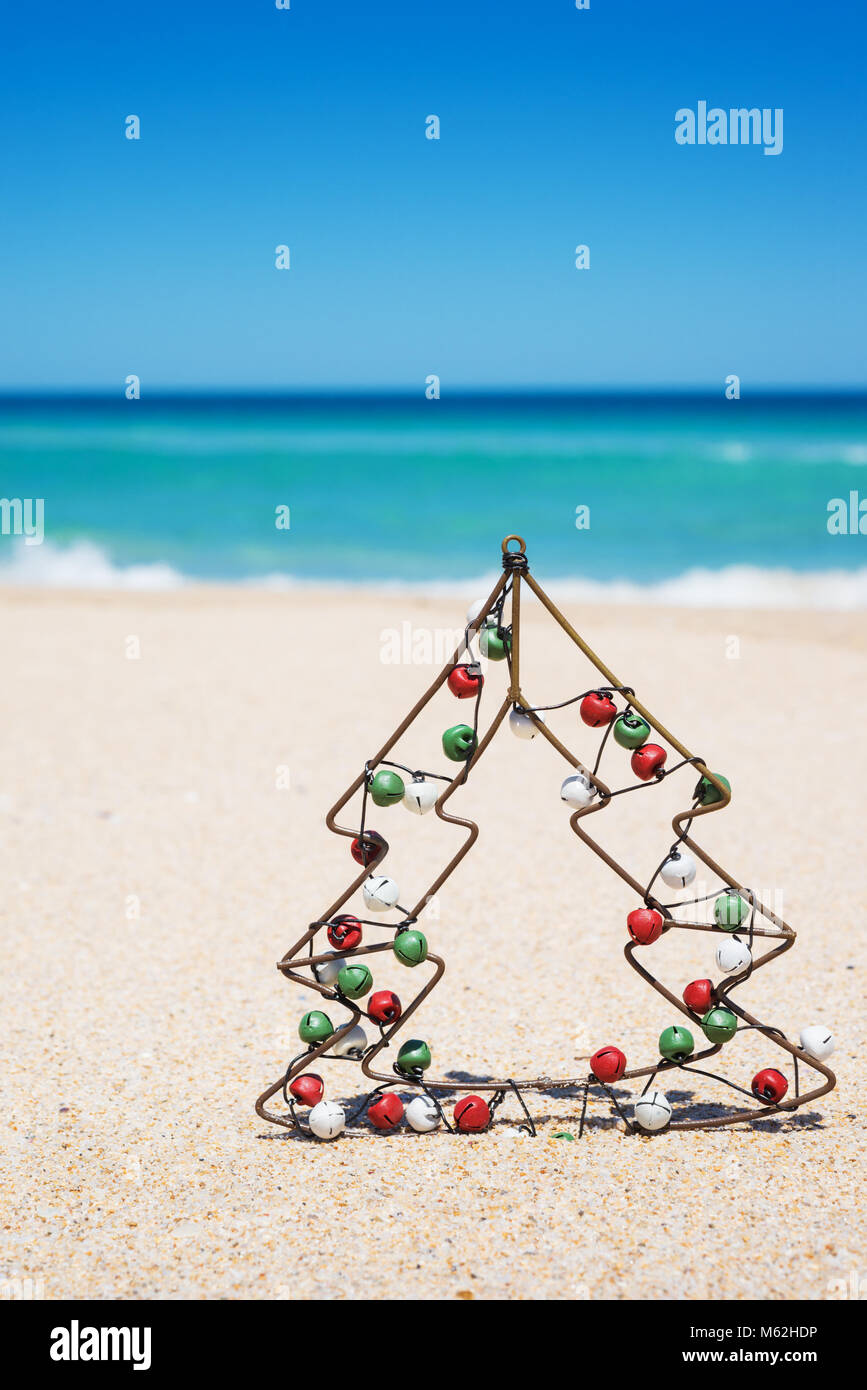 small metal christmas tree with jingle bells on the beach new year and christmas holiday - Small Metal Christmas Tree small metal christmas tree with jingle bells on the beach new year and christmas holiday - Small Metal Christmas Tree