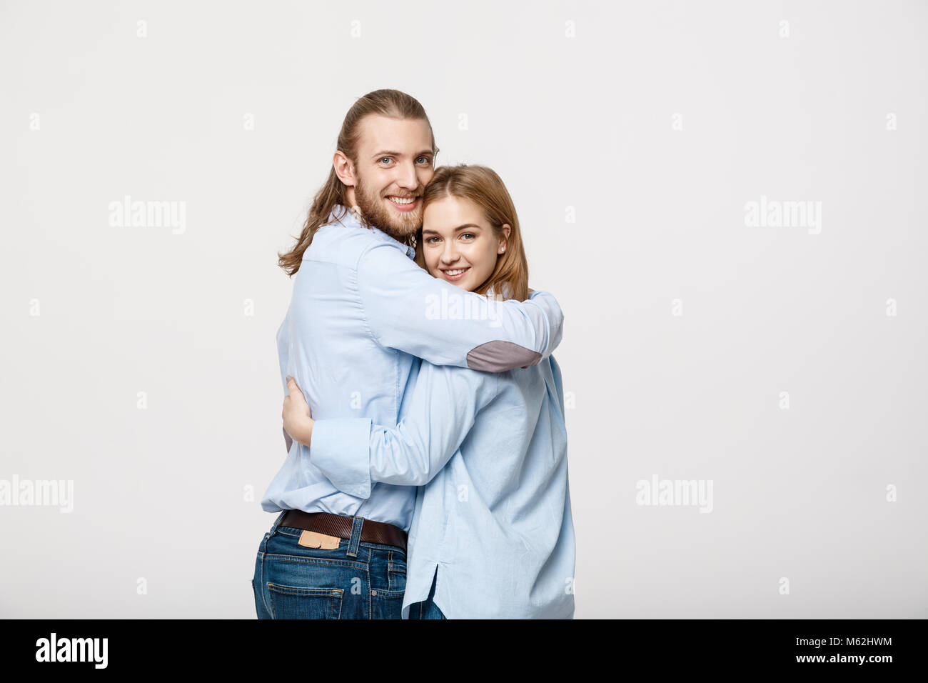 Portrait of cheerful young couple standing and hugging each other on ...