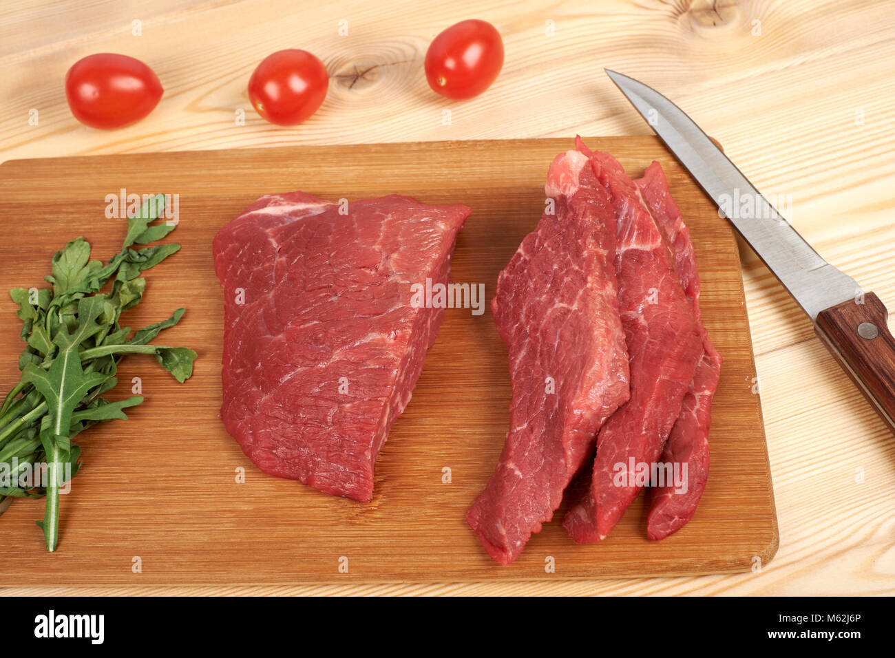 https://c8.alamy.com/comp/M62J6P/sliced-raw-beef-on-cutting-board-and-vegetables-M62J6P.jpg