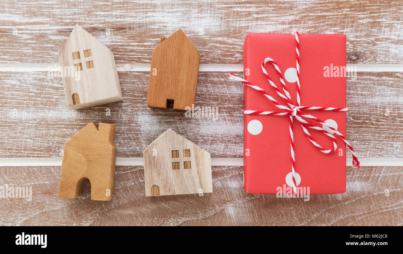 House model with gift box on wooden table background from top view ...