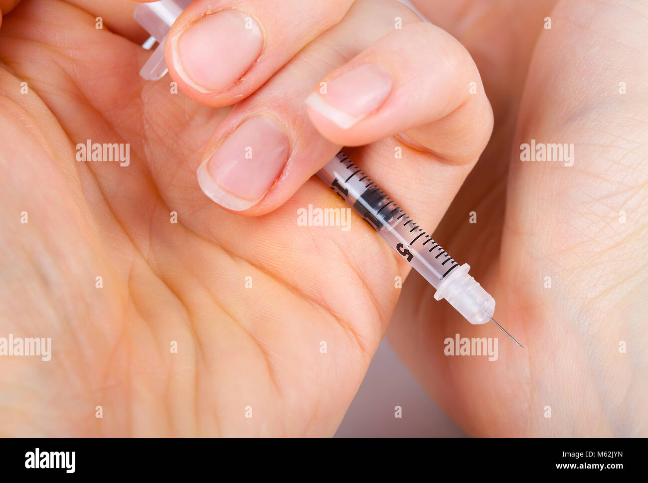 Insulin syringe on a gray background. Closeup Stock Photo