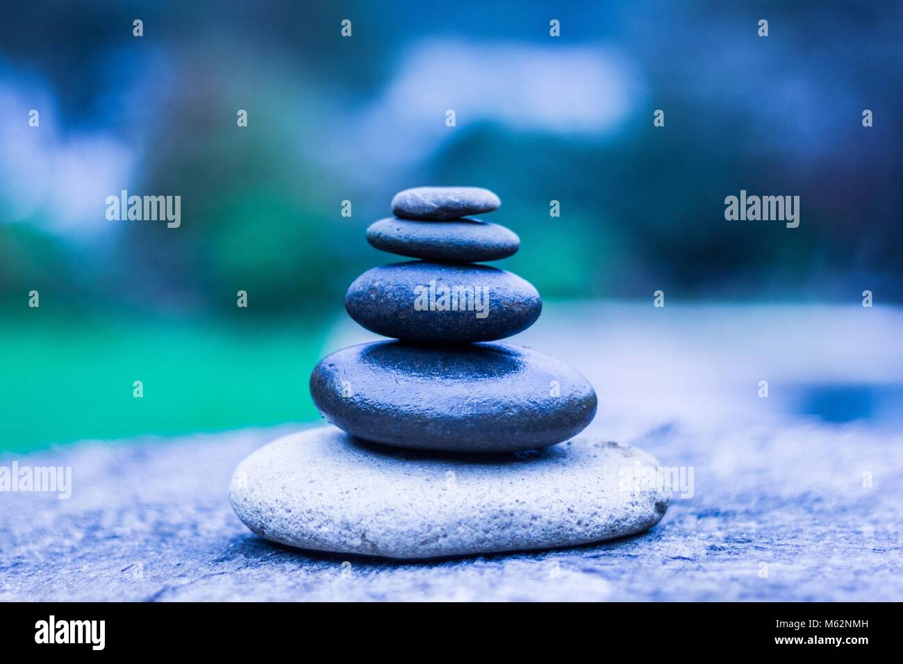 Five zen stones in equilibrium in blue cold tones. Relax, peaceful concept Stock Photo