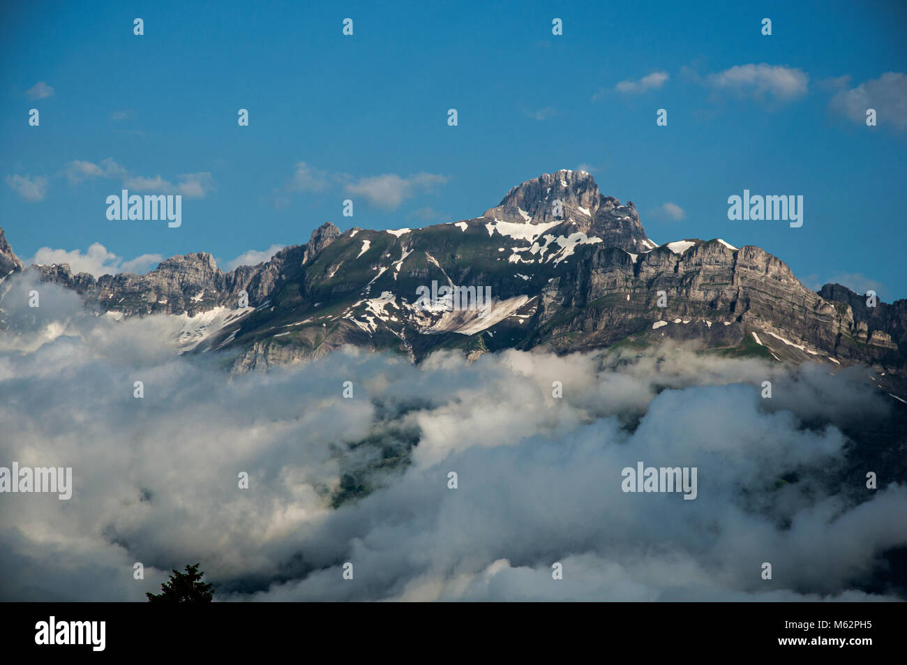 Snowy peaks and alpine mountains panorama with blue sky and clouds in Saint-Gervais-Les-Bains/Le Fayet. Near the Mont Blanc in the French Alps. Stock Photo