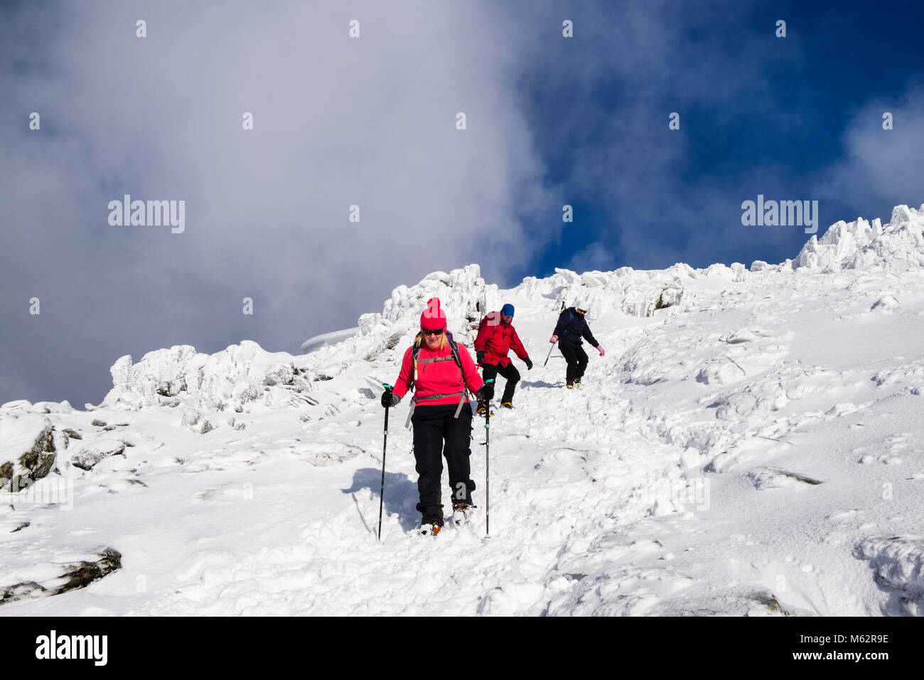 Well equipped hikers with crampons and ice axes hiking down from Snowdon summit in deep snow in winter in Snowdonia National Park. Wales, UK, Britain Stock Photo