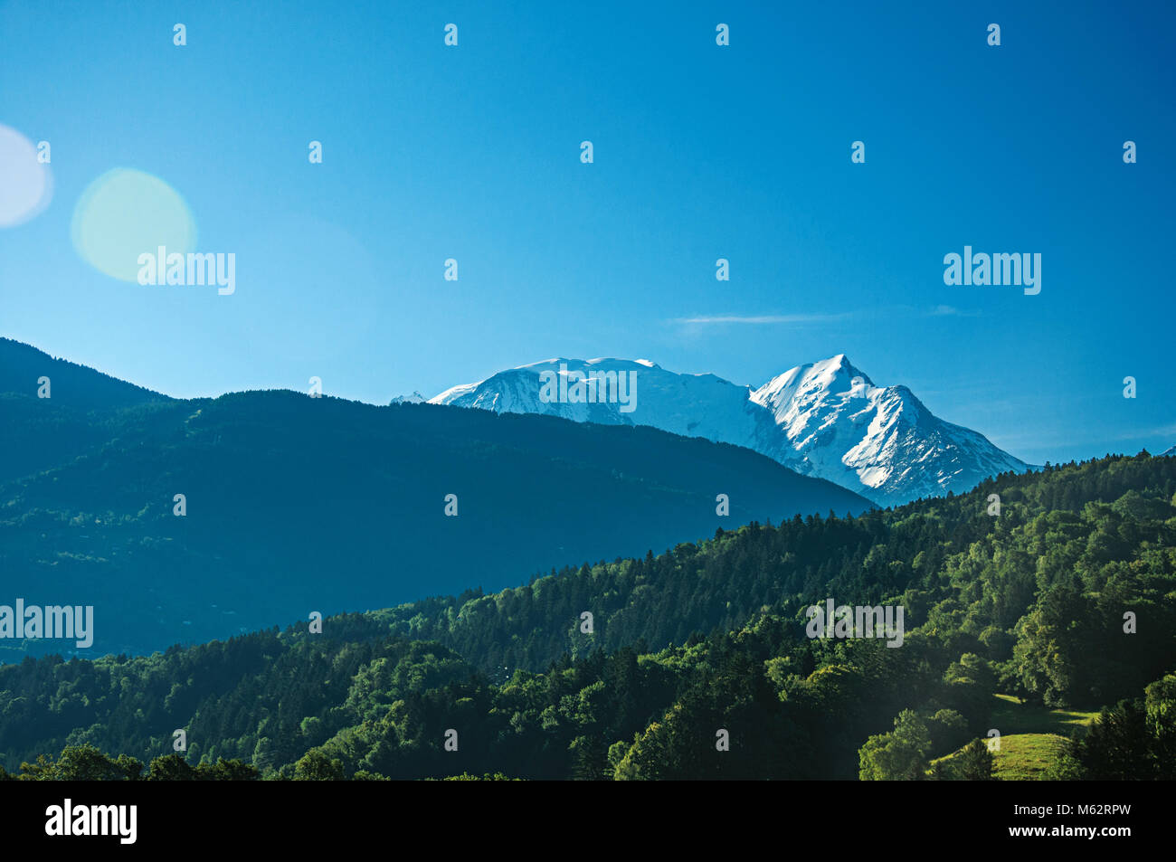 Alpine mountain landscape with forests and blue sky, near Saint-Gervais-Les-Bains. A famous ski resort near the Mont Blanc in the French Alps. Stock Photo