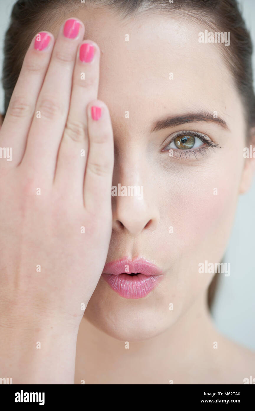 Pouting woman with hand over face Stock Photo