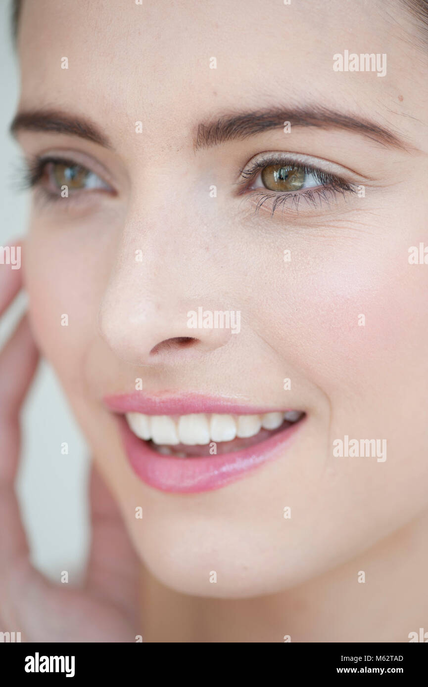 Smiling woman with hand to face Stock Photo