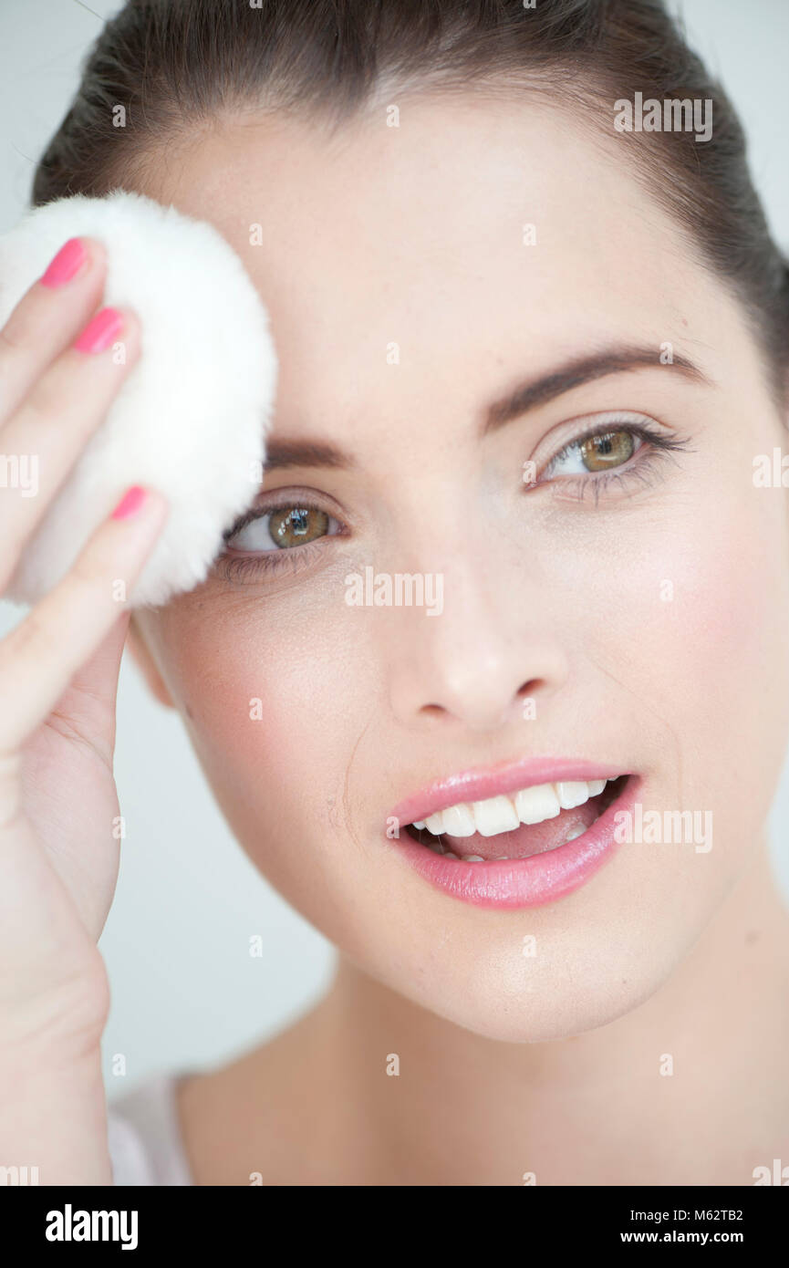 Woman with powder puff to forehead Stock Photo